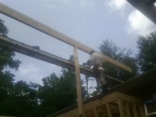 Carpenter setting a ridge beam over a new addition frame — Ice Dam Removal by Roofing Brothers in Los Molinos