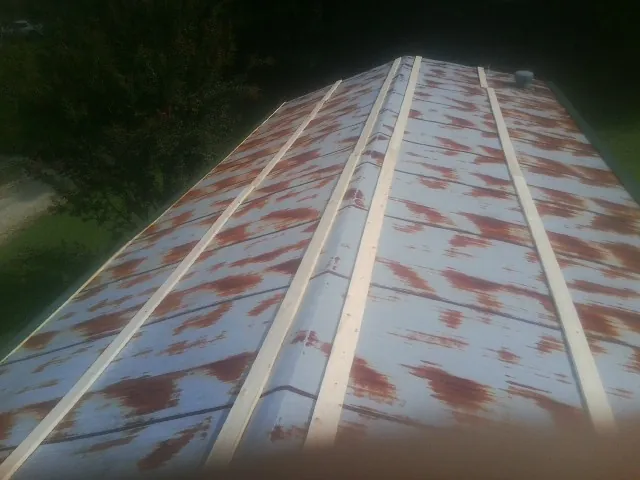 Rusted metal roof panels with new wood purlins before replacement — Storm Damage Roof Repair in Los Molinos by Roofing Brothers